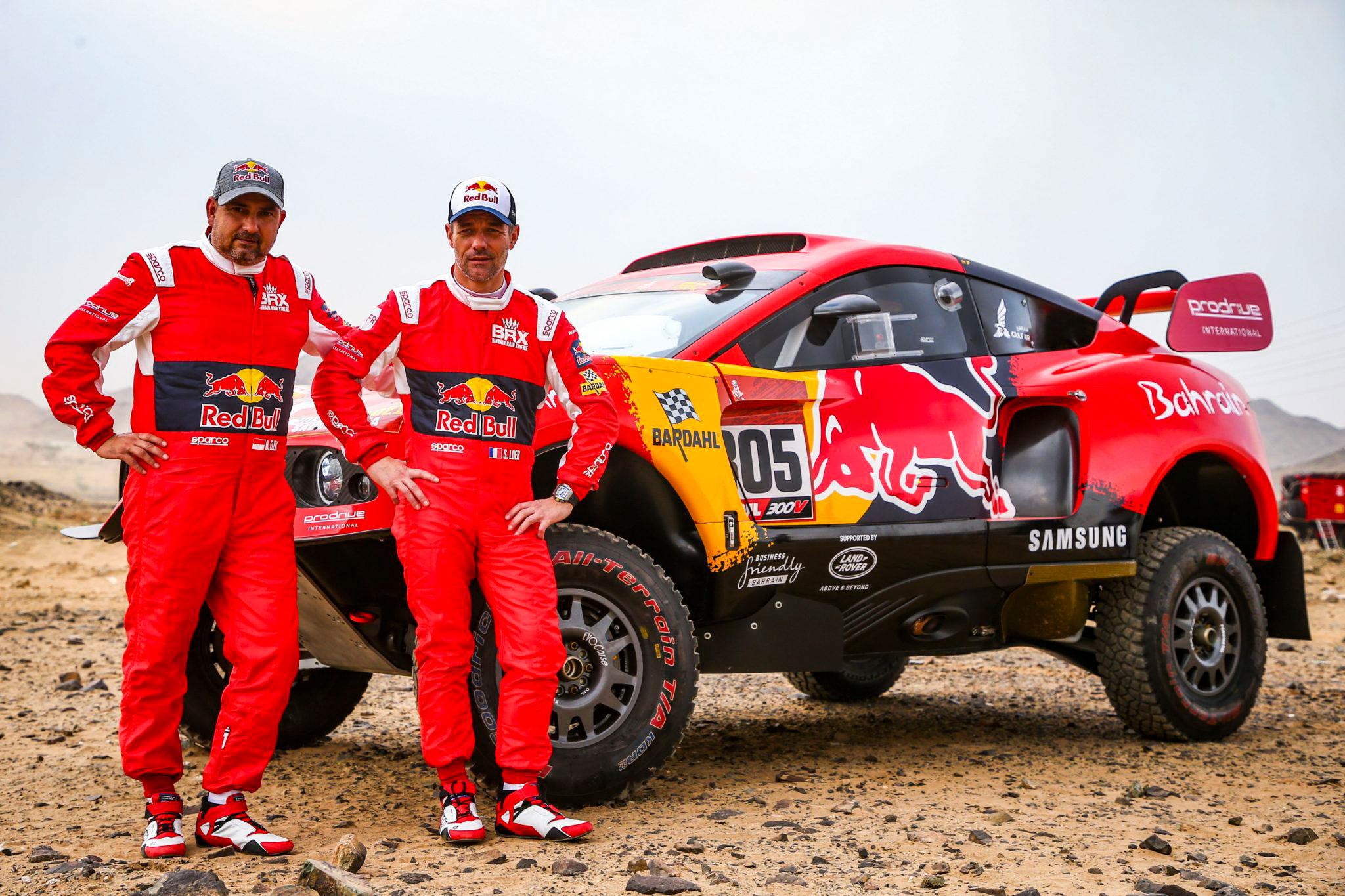 Pilot Daniel Elena i kierowca Sébastien Loeb pozują przed swoim samochodem rajdowym Prodrive Hunter na Rajdzie Dakar 2021 w Arabii Saudyjskiej